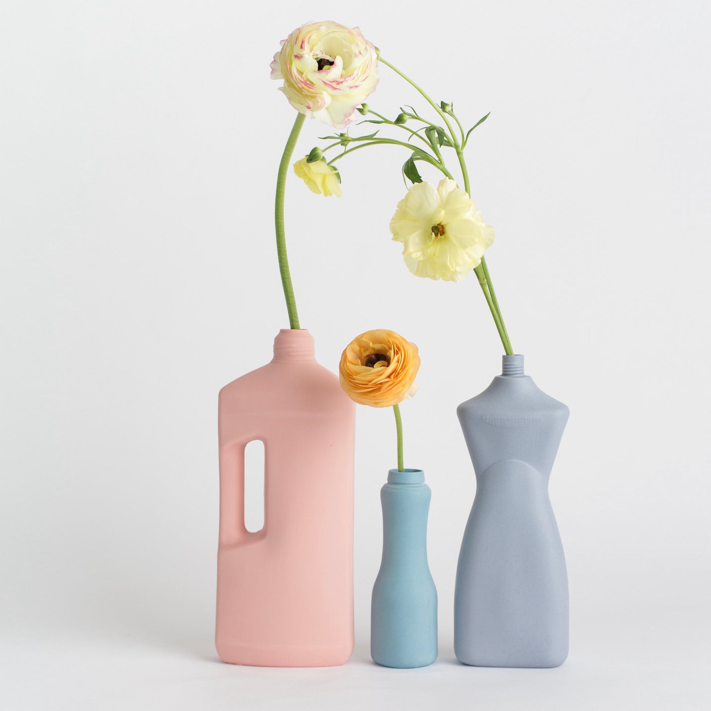 Porseleinen, handgemaakte vazen van Foekje Fleur. Deze vazen heten Bottle Vase en hebben de vorm van een plastic fles met schoonmaakmiddelen.