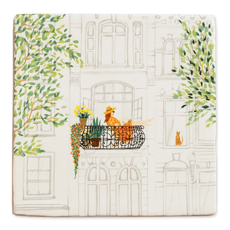 StoryTile Mijn Favoriete Plek. Op deze StoryTile staat een oud herenhuis met een Frans balkon waarop een vrouw met zomerhoed zit te relaxen tussen de planten. Voor het raam zit een rode kater. Aan beide zijden van de tegel zie je groene boomtakken.