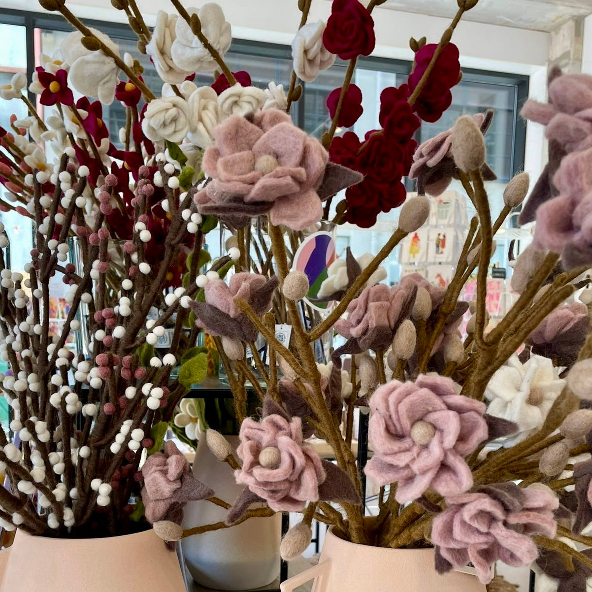 Vilten takken met vilten bloemen van Gry & Sif. Deze bossen bloemen staan in een vaas. Vilten magnoliatakken, vilten rozen en vilten katjes. 