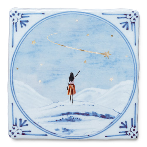 StoryTile Dat Wensen Uit Mogen Komen. Op deze StoryTile staat een fee met een rode rok (of een meisje) dat naar een vallende ster wijst. De sterren op deze tegel zijn goud. 