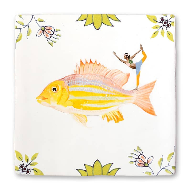Storytile In de flow. Op deze siertegel staat een vis met geel en oranje. Op zijn rug staat een vrouw in een yogapose. 