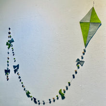 Load image into Gallery viewer, Vlieger slinger van vilt in de kleuren groen en blauw. Deze slinger hangt aan een muur. Hij is 3 meter lang. Aan de lijn hangen vilten balletjes en strikjes in de kleuren groen, lichtblauw, turquoise en beige. 
